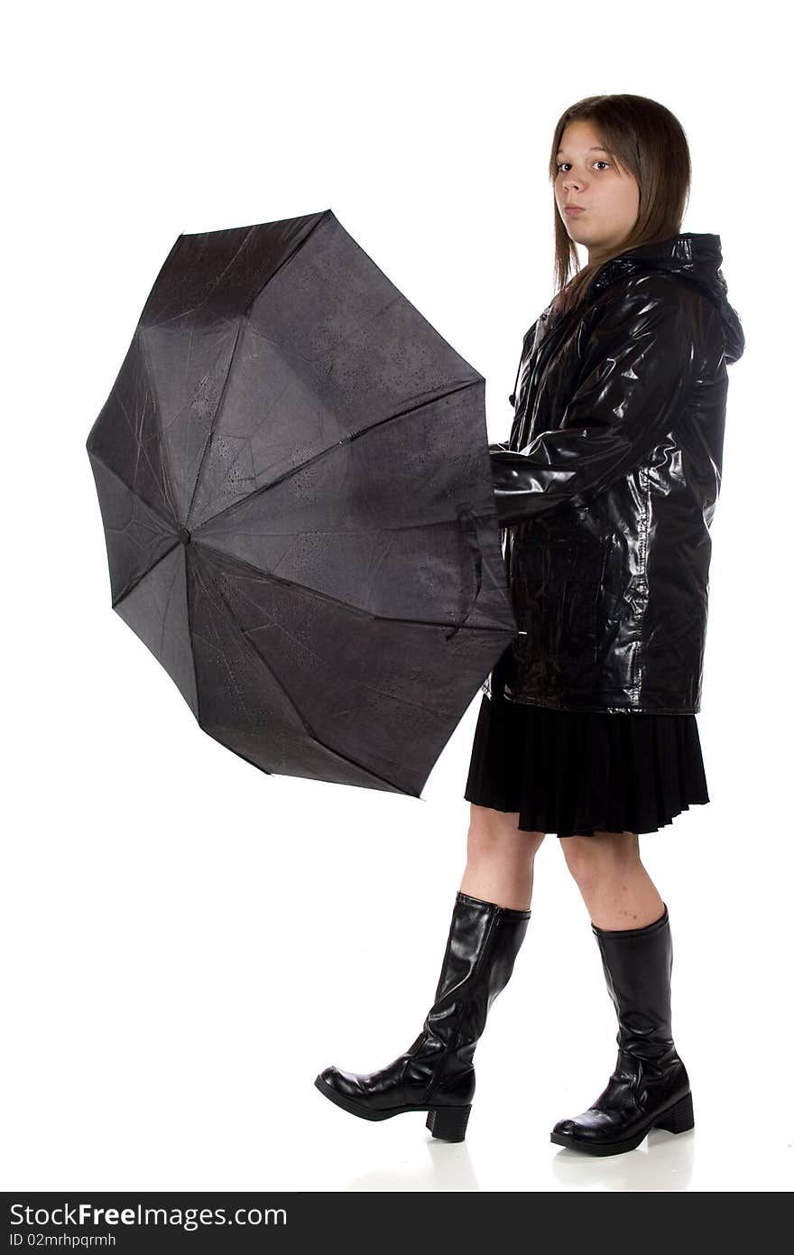 A young teen girl in rain gear, wondering if she can take her umbrella down.  Isolated on white. A young teen girl in rain gear, wondering if she can take her umbrella down.  Isolated on white.