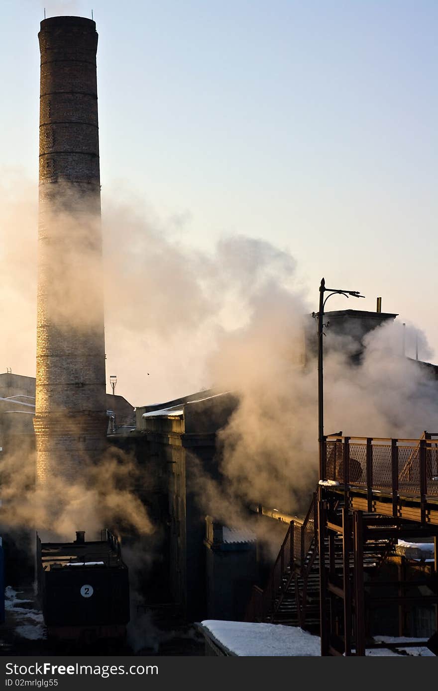 An industrial sight with a wagon a fragment of a bridge chimney and buildings in smog. An industrial sight with a wagon a fragment of a bridge chimney and buildings in smog