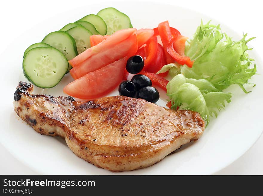 Fried pork with vegetables on a plate