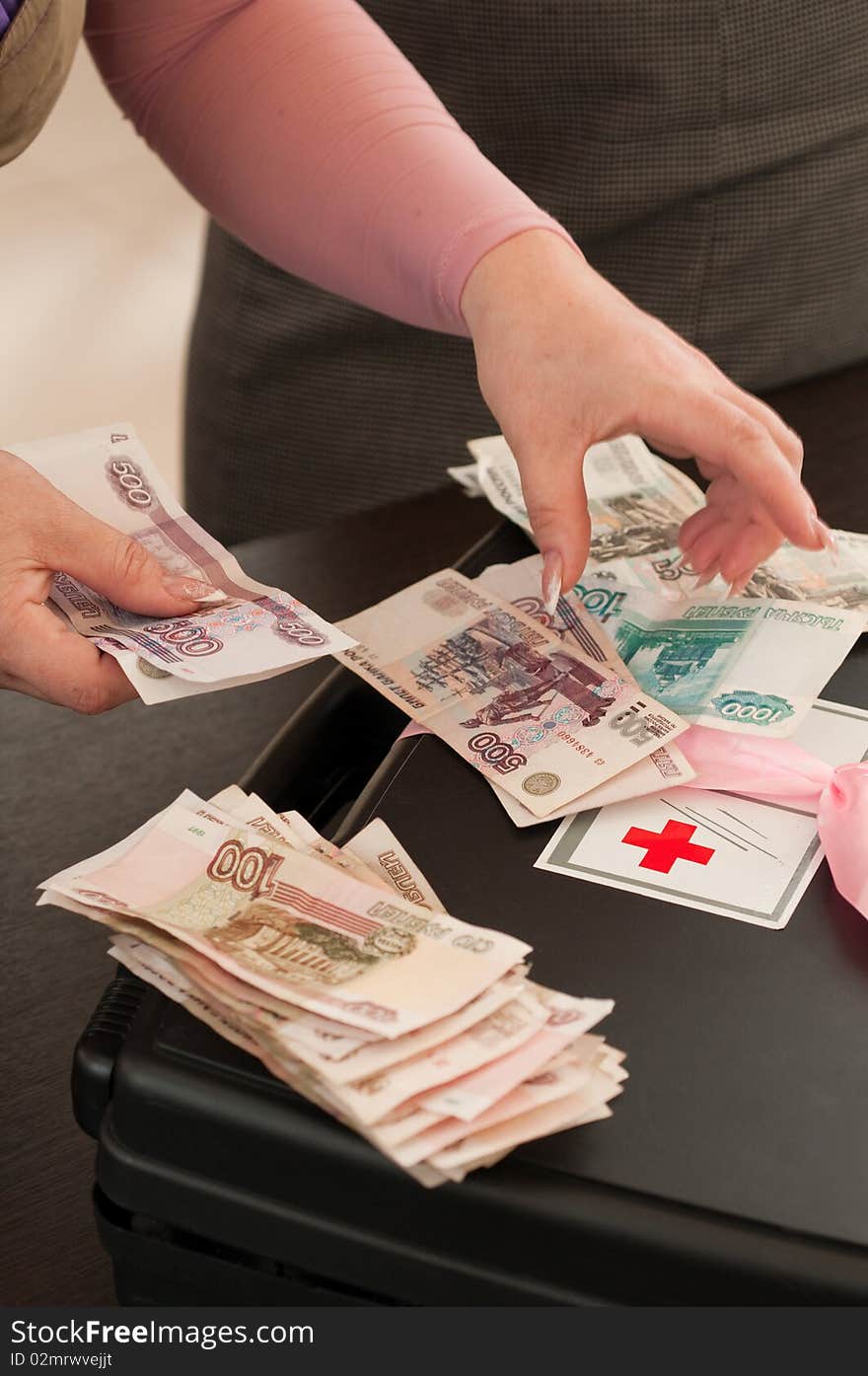 The first-aid set with a red cross and female hands counting money. The first-aid set with a red cross and female hands counting money.