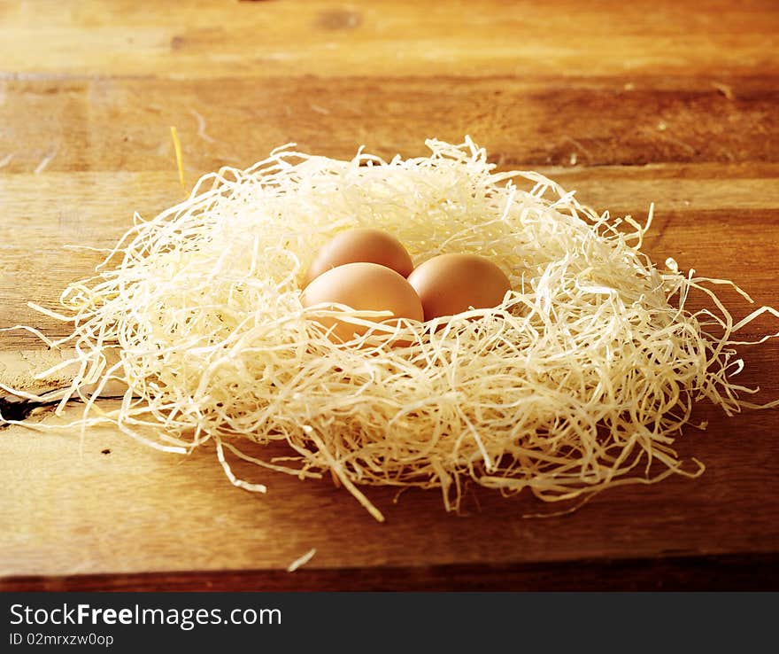 Eggs in a nest on a wooden table. Eggs in a nest on a wooden table