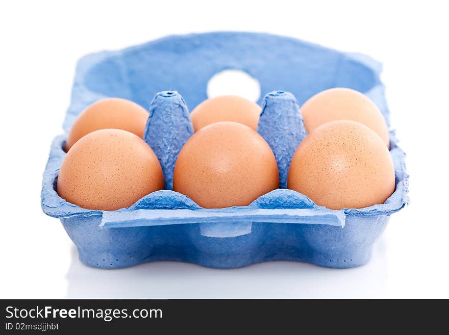 Blue box or carton of half a dozen fresh eggs isolated on white background. Blue box or carton of half a dozen fresh eggs isolated on white background