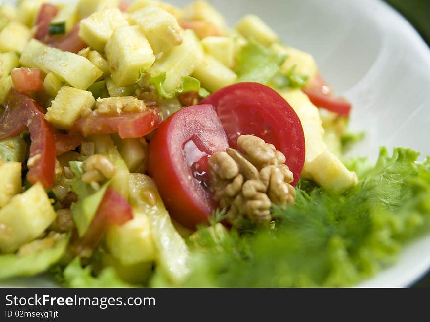 Delicious salad with fresh raw vegetables. Salad is made of: zucchini, walnuts, tomato, cucumber, lettuce leaves, turmeric, salt, oil from walnuts. Delicious salad with fresh raw vegetables. Salad is made of: zucchini, walnuts, tomato, cucumber, lettuce leaves, turmeric, salt, oil from walnuts.