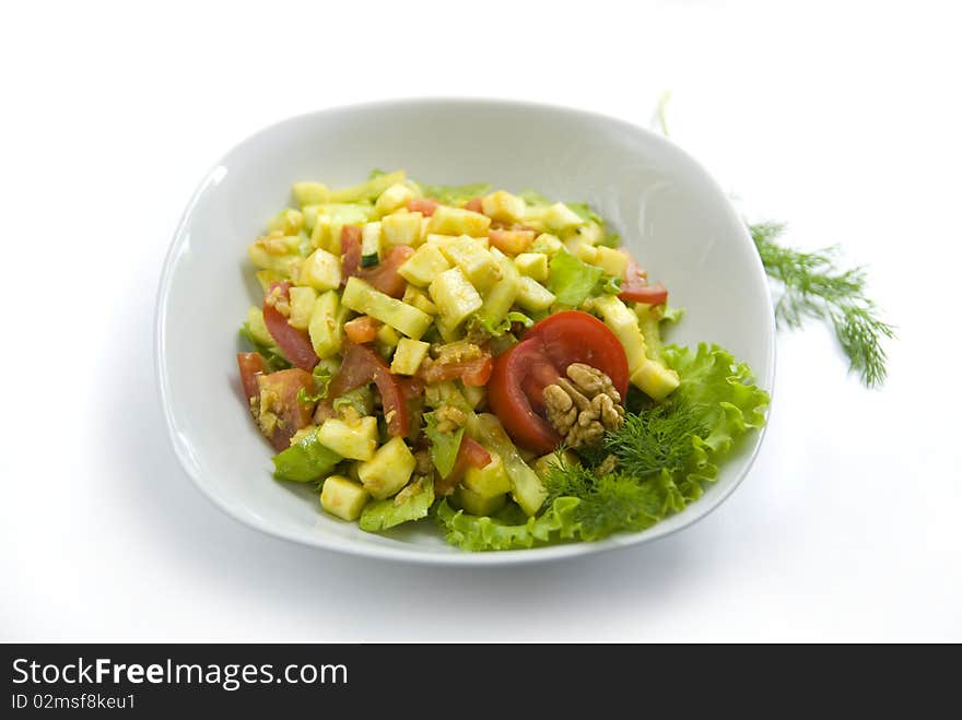 Delicious salad with fresh raw vegetables. Salad is made of: zucchini, walnuts, tomato, cucumber, lettuce leaves, turmeric, salt, oil from walnuts. Delicious salad with fresh raw vegetables. Salad is made of: zucchini, walnuts, tomato, cucumber, lettuce leaves, turmeric, salt, oil from walnuts.