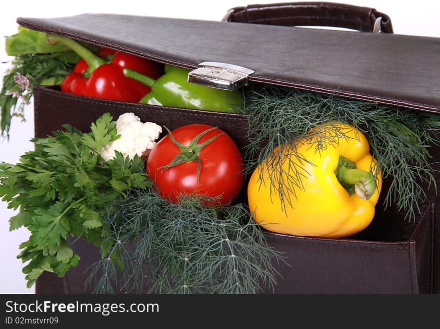 Brown briefcase with ripe fresh vegetables isolated on white background