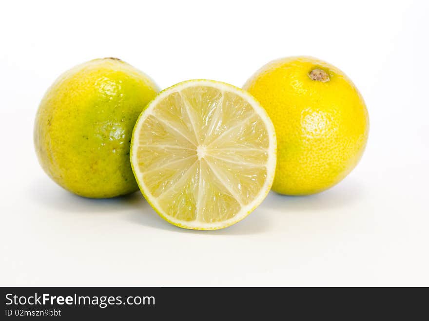 Fresh lemons in the foreground on white background