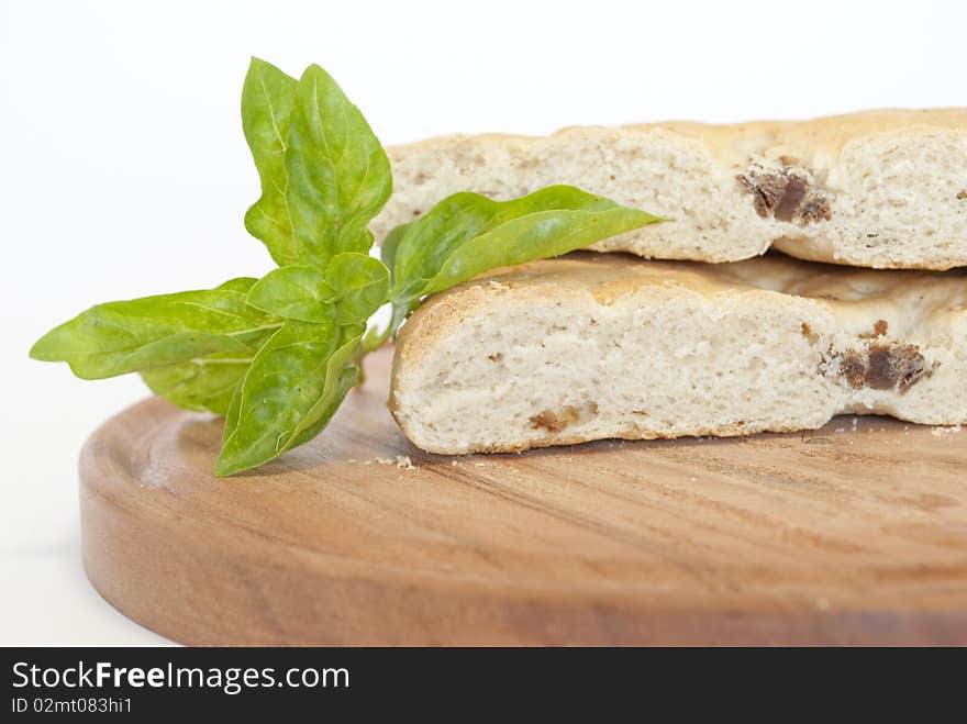 Pigskin bread and basil leaves in the foreground. Pigskin bread and basil leaves in the foreground