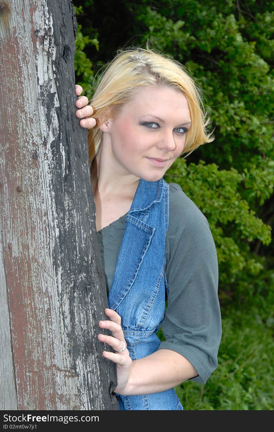 Pretty blond girl outdoors against tree