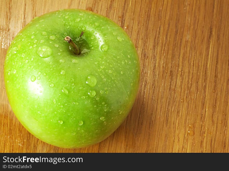 Green apple covered in dew on the kitchen table. Green apple covered in dew on the kitchen table