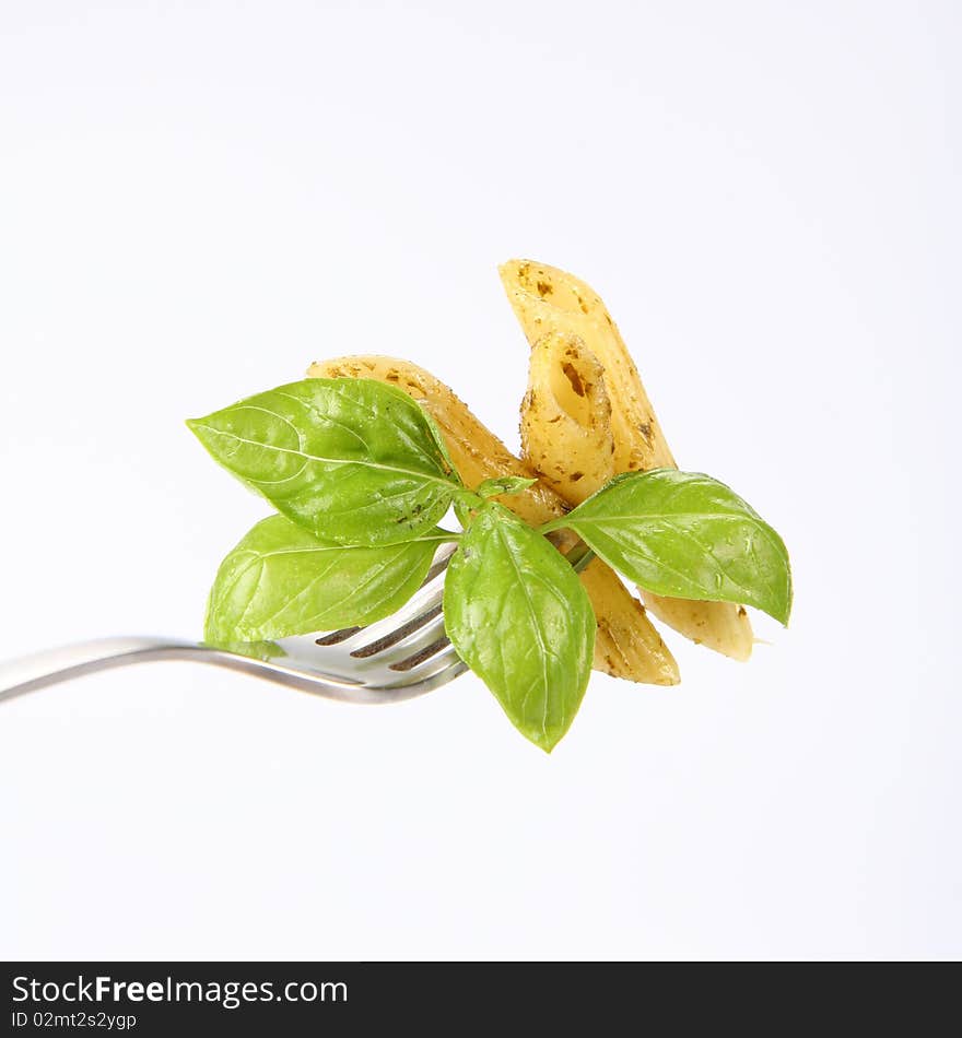 Penne with pesto on a fork