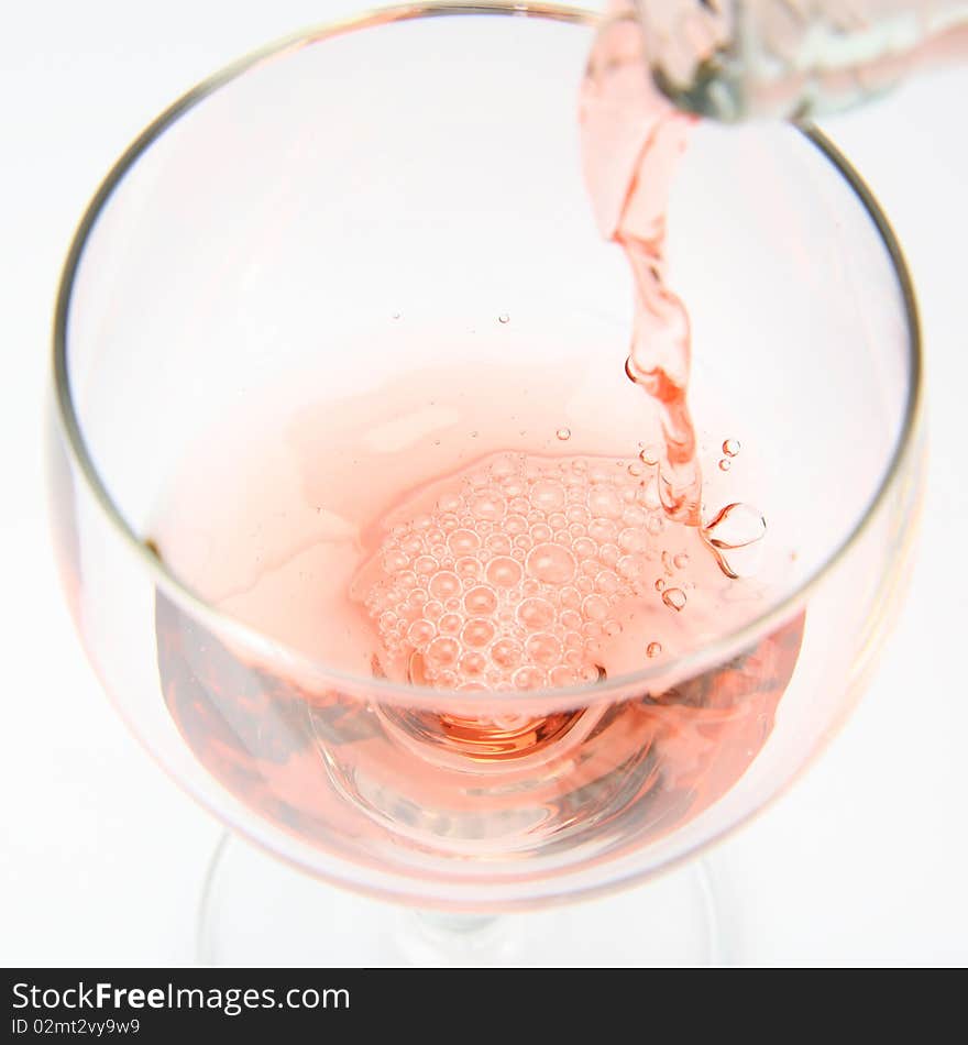 Pink wine being poured into a wine glass