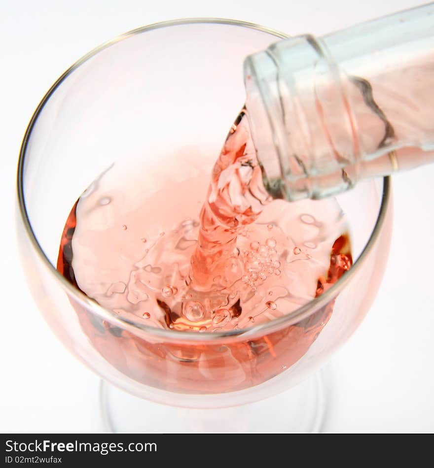 Pink wine being poured into a wine glass