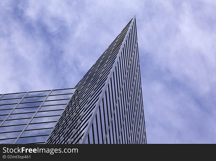 Tilted shot, looking up at a blue glass modern office building. Horizontal shot. Tilted shot, looking up at a blue glass modern office building. Horizontal shot.