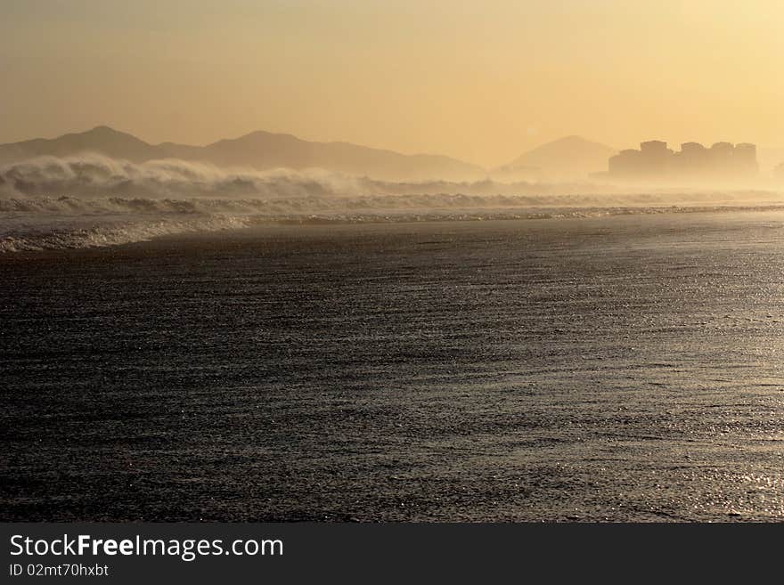 Large waves on hazy urban beach. Large waves on hazy urban beach