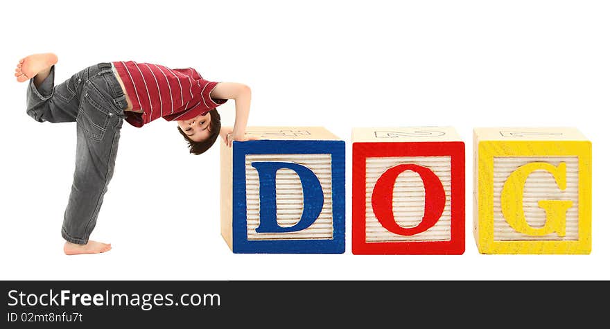 Giant alphabet blocks and adorable seven year old boy spelling out the word dog. Giant alphabet blocks and adorable seven year old boy spelling out the word dog