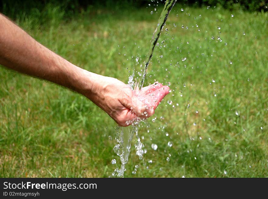 Water splashing out of a man's cupped hand. Water splashing out of a man's cupped hand