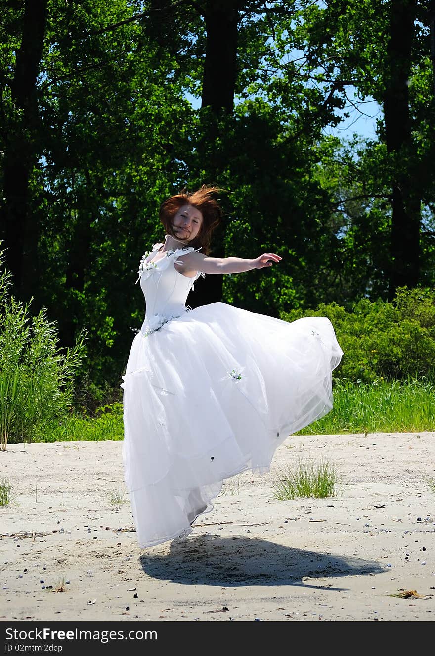 Bride jumping on a sandy beach. Bride jumping on a sandy beach