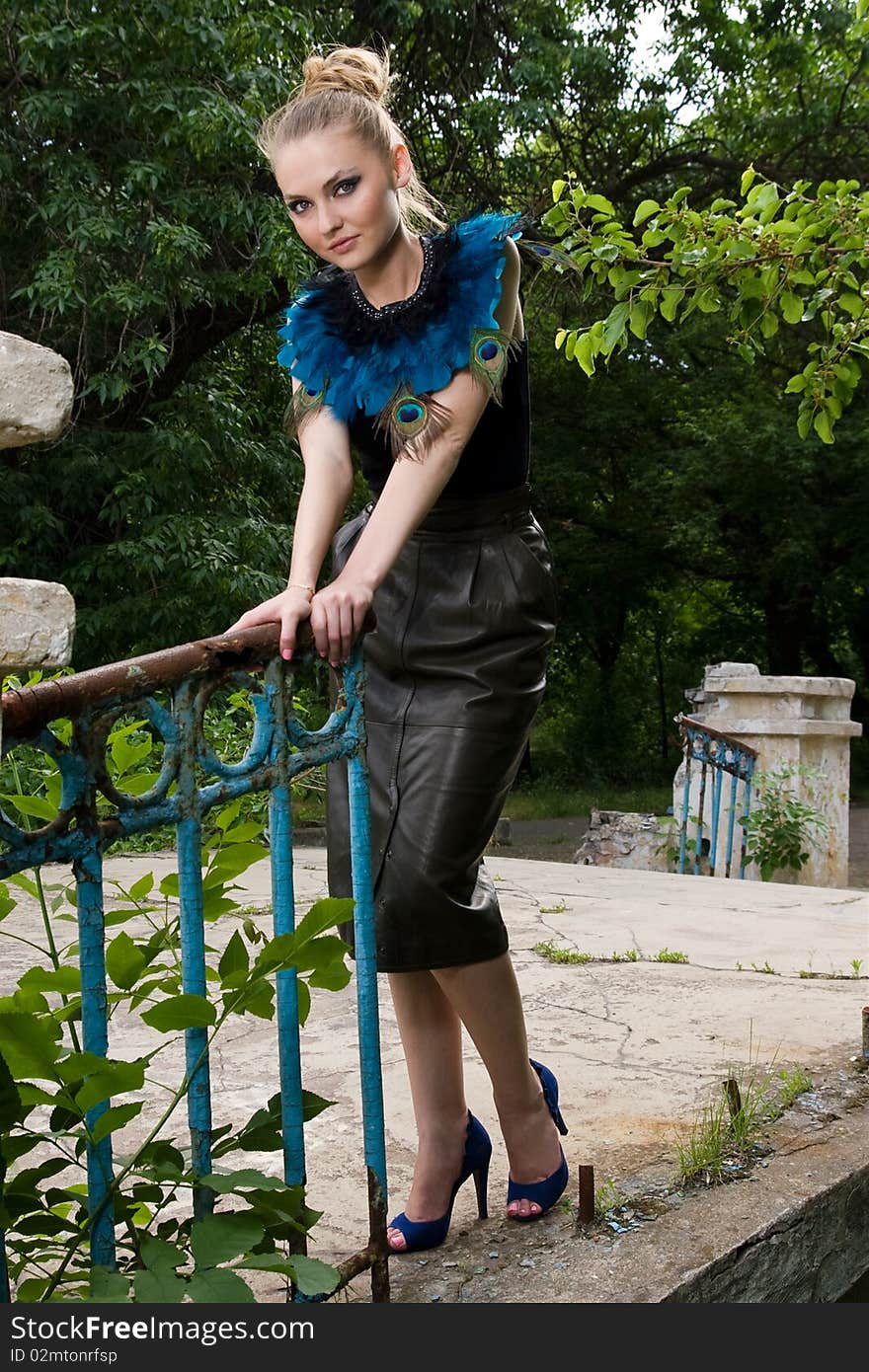 Girl in blouse with peacock feathers posing