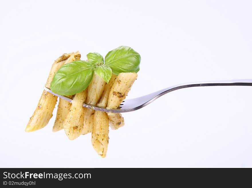 Penne with pesto on a fork