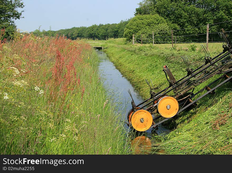 Mowing shore side of a ditch for flow and abduction of water. Mowing shore side of a ditch for flow and abduction of water