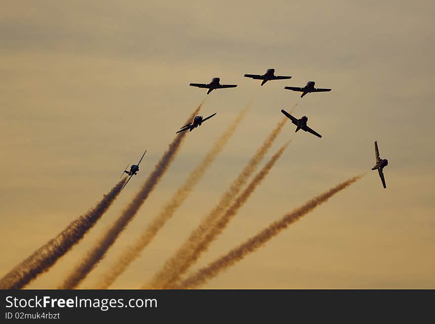 Canadian Snowbirds jet aerobatic team flying CT-114 tutor jet airplanes at sunset