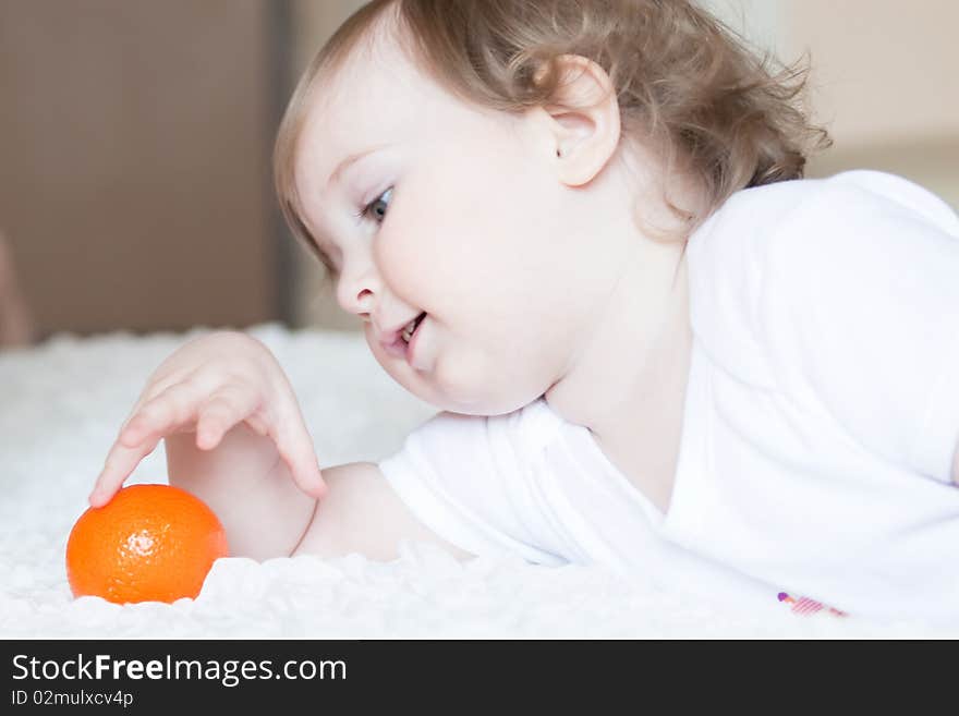 Little cute girl playing with fresh tangerine. Little cute girl playing with fresh tangerine