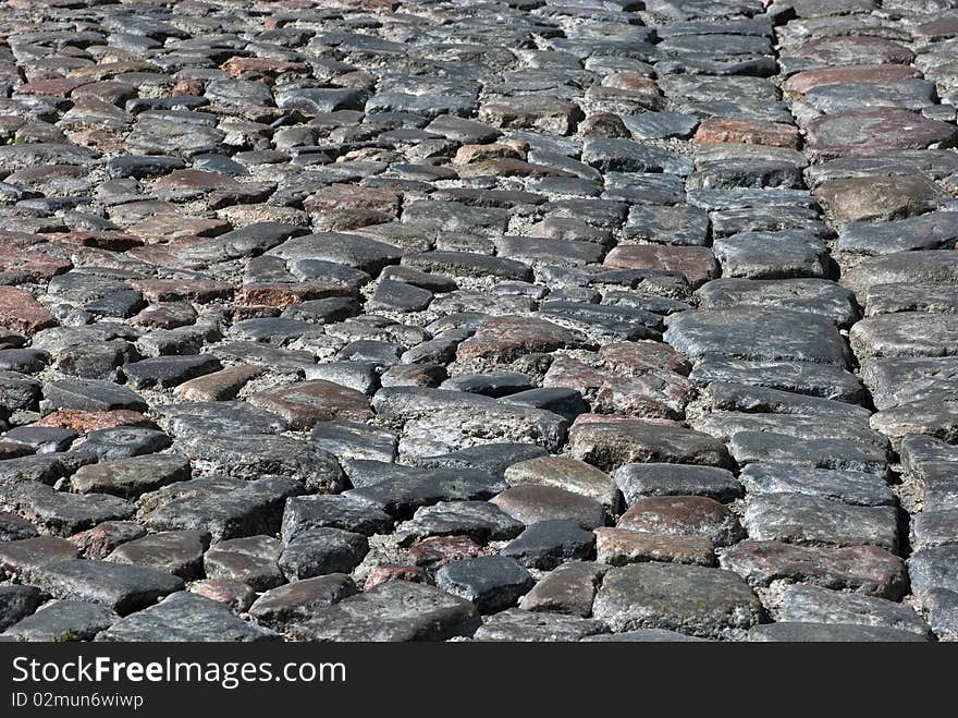 Cobbled road close-up; texture; background. Cobbled road close-up; texture; background