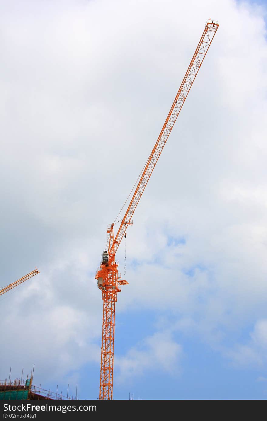 Cranes on a construction site with blue sky.