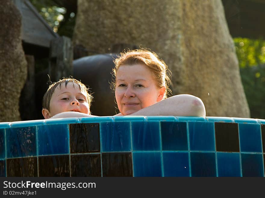 Mother with child is enjoing the fresh water in the pool and both looking happy. Mother with child is enjoing the fresh water in the pool and both looking happy