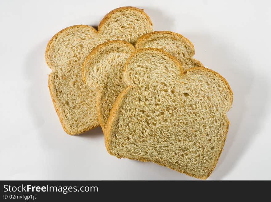 Three slices of wheat bread against a white background. Three slices of wheat bread against a white background