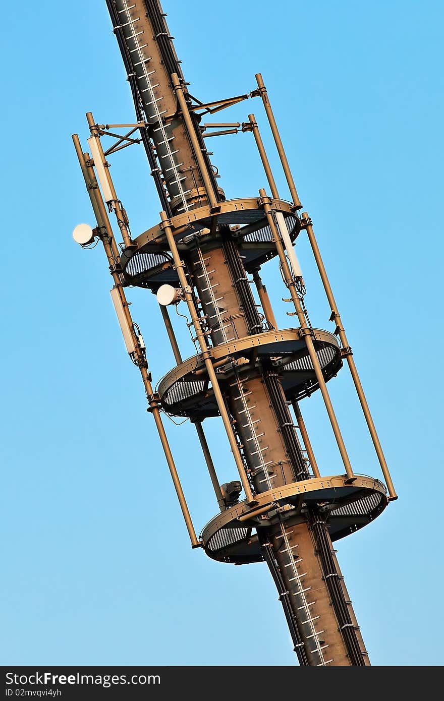 Telecommunication monopole tower section with antennas over blue sky. Telecommunication monopole tower section with antennas over blue sky.