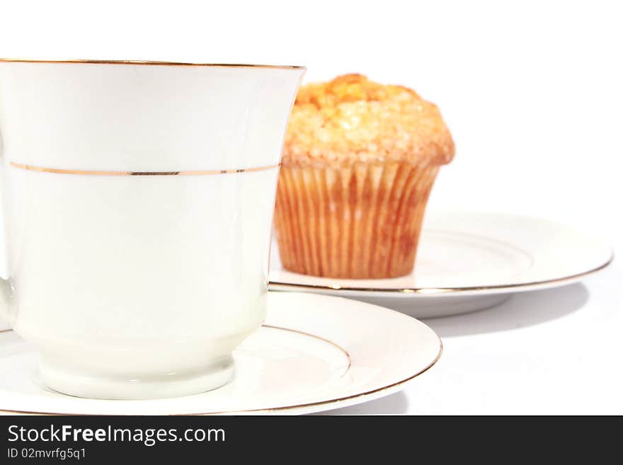 White cup with saucer and muffin. White cup with saucer and muffin