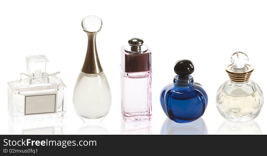 Five different perfumes on a white background with reflection