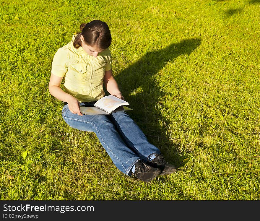 This photo shows a girl with a book. This photo shows a girl with a book