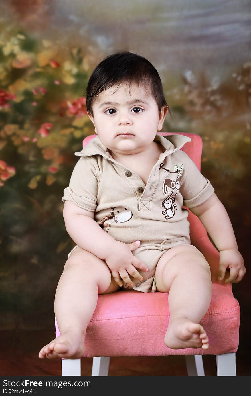 A cute chubby baby sitting on a chair. A cute chubby baby sitting on a chair.