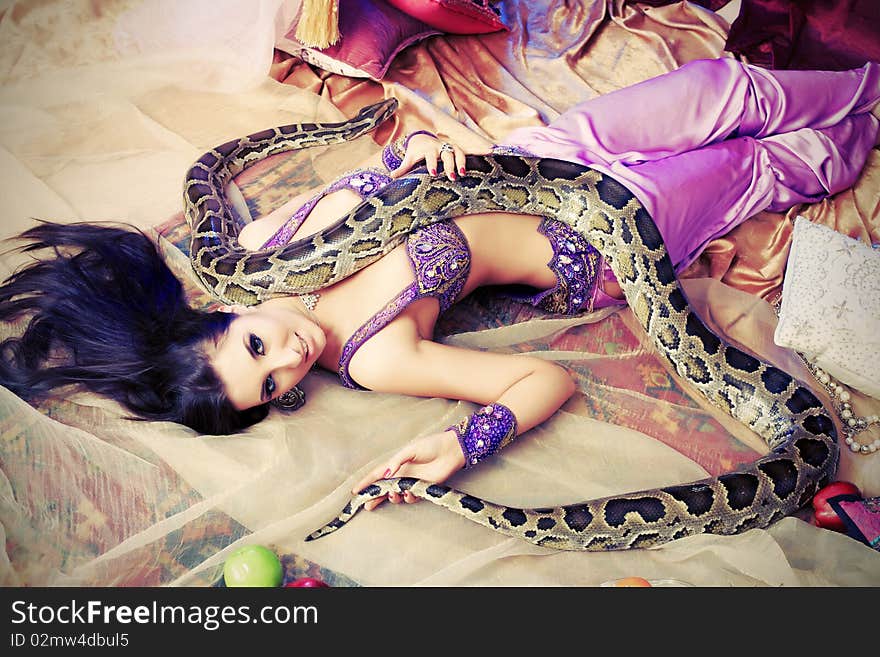 Shot of an oriental woman posing with a python. Shot of an oriental woman posing with a python.