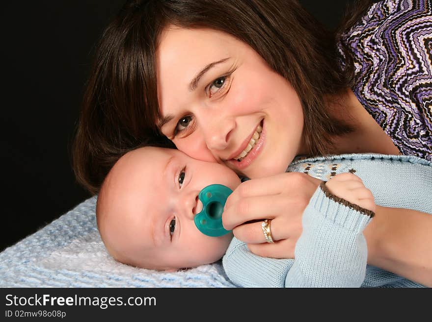 Beautiful brunette mother with her baby boy dressed in blue. Beautiful brunette mother with her baby boy dressed in blue