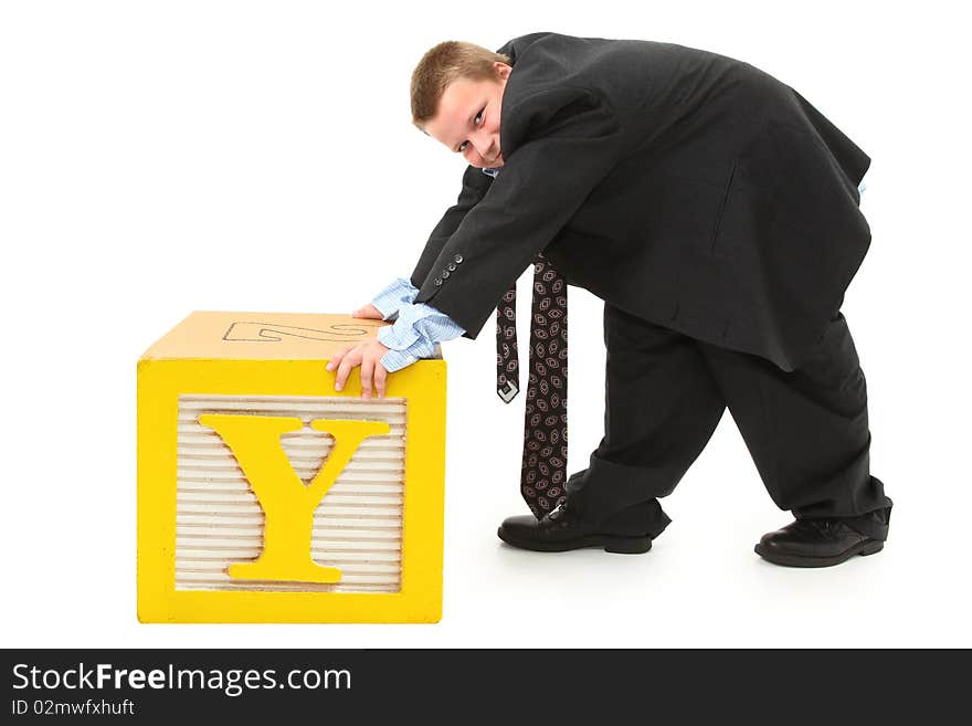 The letter Y on alphabet block being pushed by handsome ten year old boy in over sized suit. The letter Y on alphabet block being pushed by handsome ten year old boy in over sized suit.