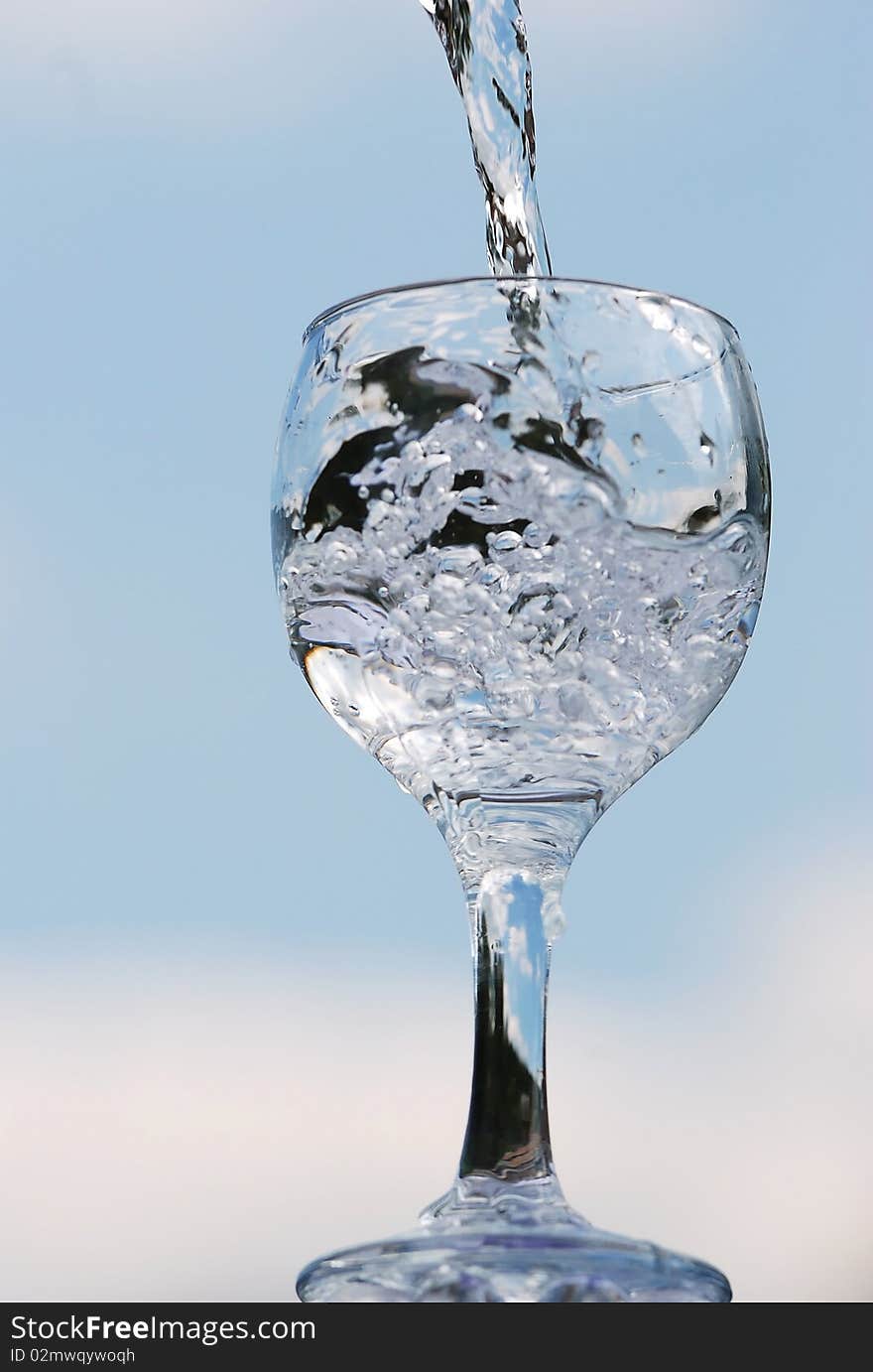 Glass in which flows pure water from a bottle. Glass in which flows pure water from a bottle