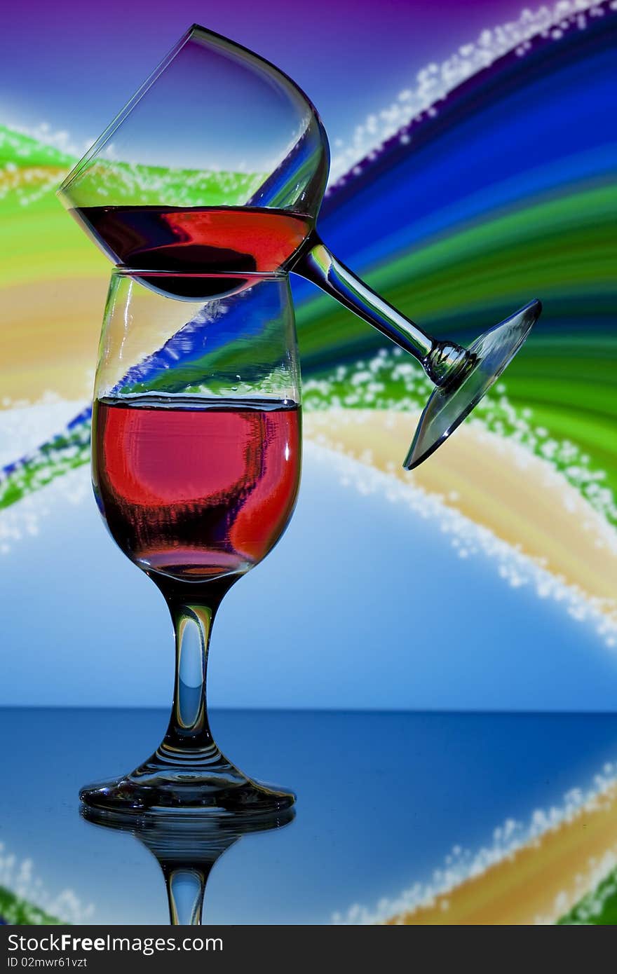 Two glasses of red wine on colorful swirl background. Two glasses of red wine on colorful swirl background