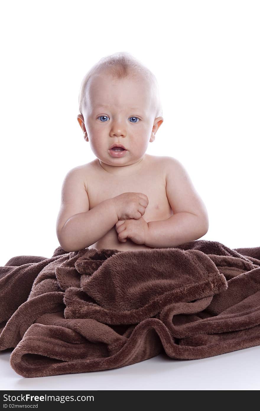 Beautiful baby under a brown towel on white background