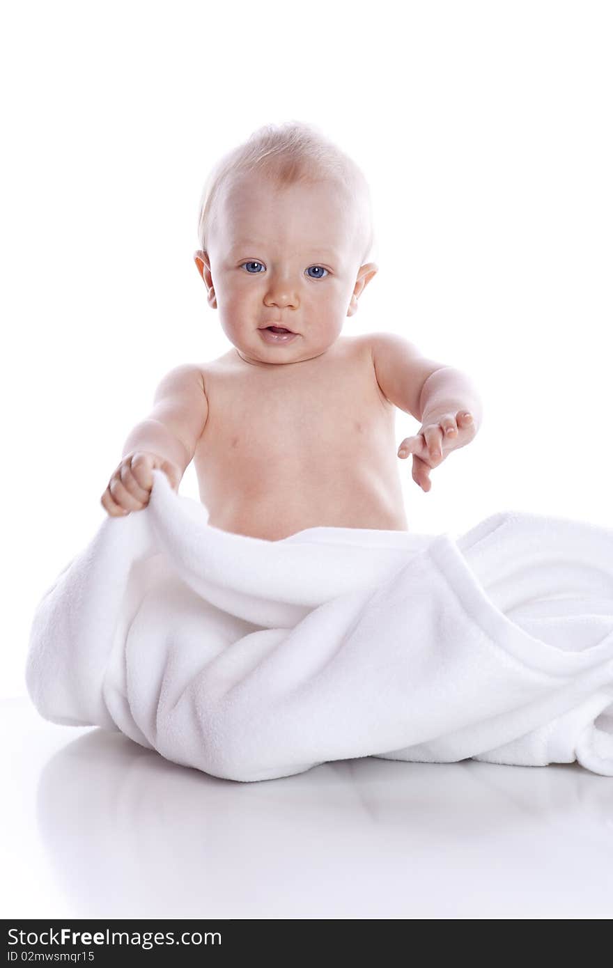 Beautiful baby under a white towel on white background