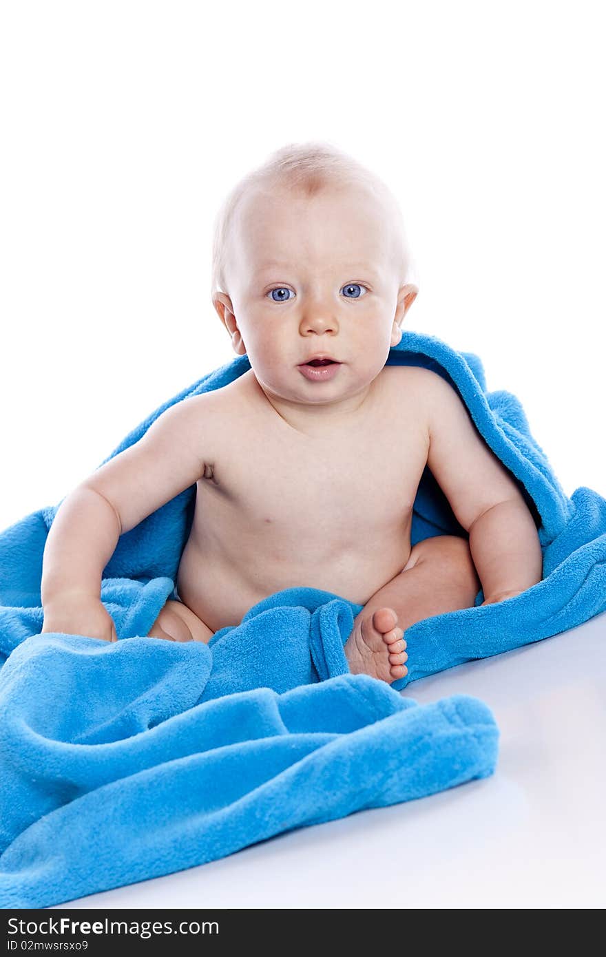 Beautiful baby under a blue towel on white background