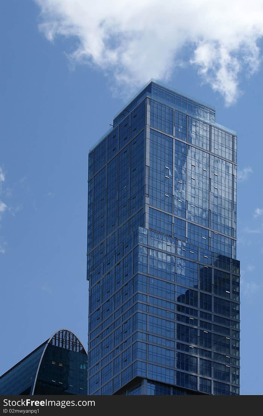 Reflection of a cloudy sky in glass wall of an office building