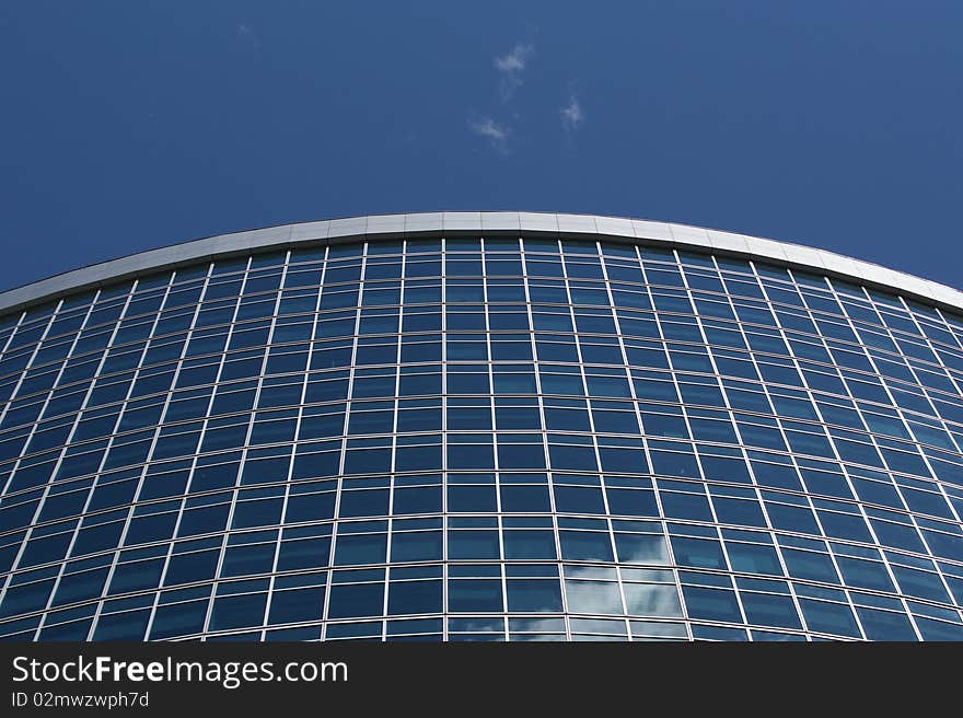 Reflection of a cloudy sky in glass wall of an office building