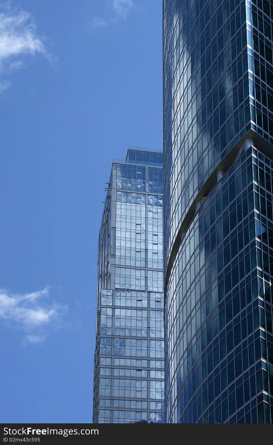 Reflection of a cloudy sky in glass wall of an office building