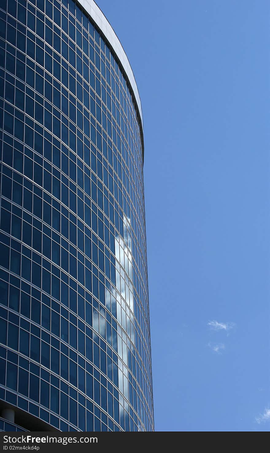 Reflection of a cloudy sky in glass wall of an office building