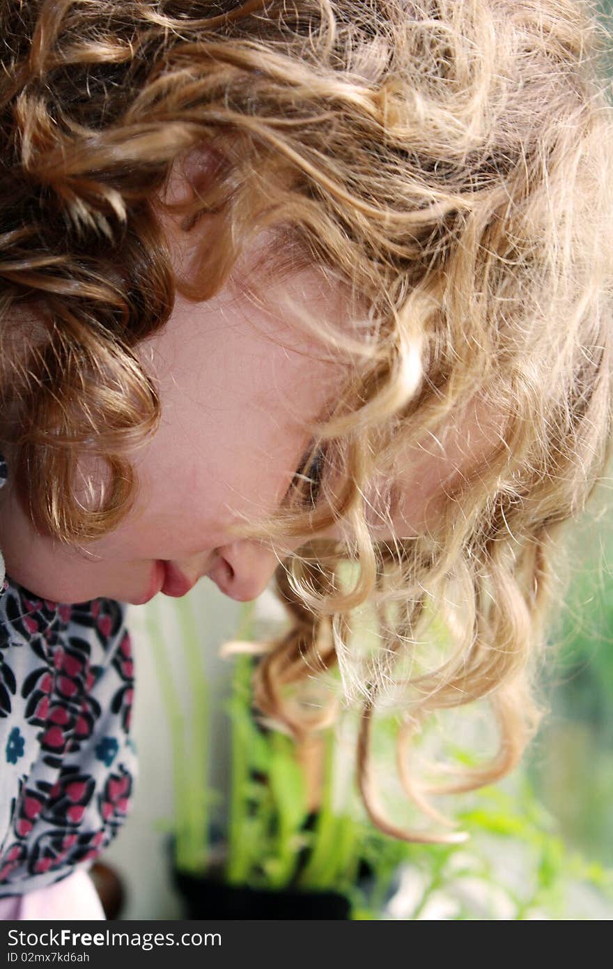 Little girl sitting by the window with a sad face. Little girl sitting by the window with a sad face