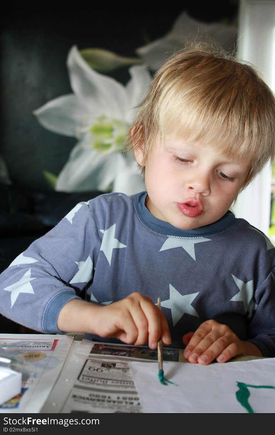 Concentrated boy painting for his mother