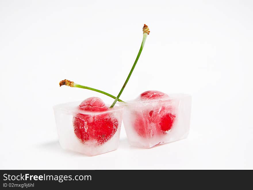 Two frozen cherries on white background